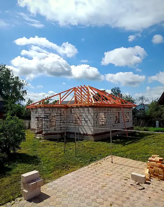 Дом из газоблока со стропильной системой вальмовой крыши